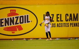 Geraldo Perdomo entre la basura arrojada durante el Águilas vs. Leones. (Especial)