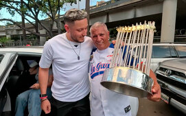 Miguel Rojas y su padre con el trofeo de los Dodgers de la Serie Mundial 2024 (FOTO: Captura de pantalla)