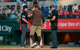 Los dos umpires intercambiando papeletas en el Padres vs. Rangers (Foto: AP)
